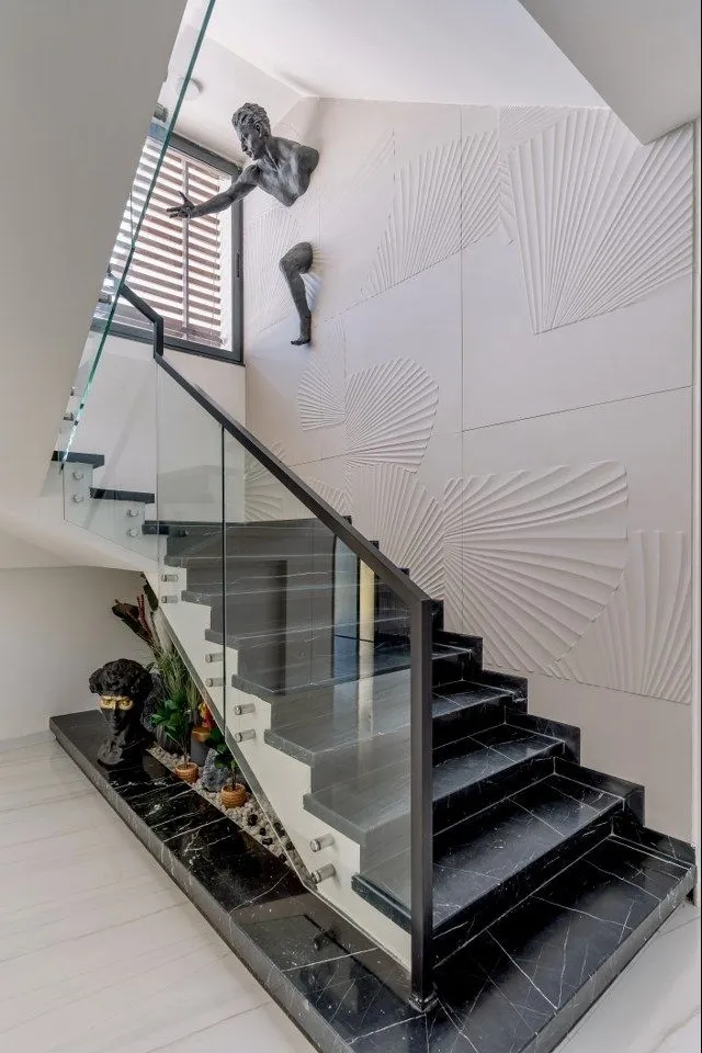 Minimal metal handrail detailing staircase design with artistic feature wall