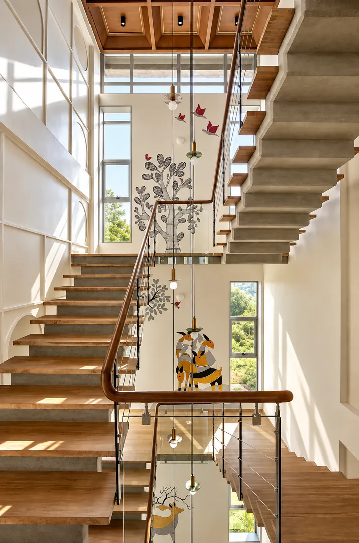 Sleek glass and metal railing staircase with artistic wall decor