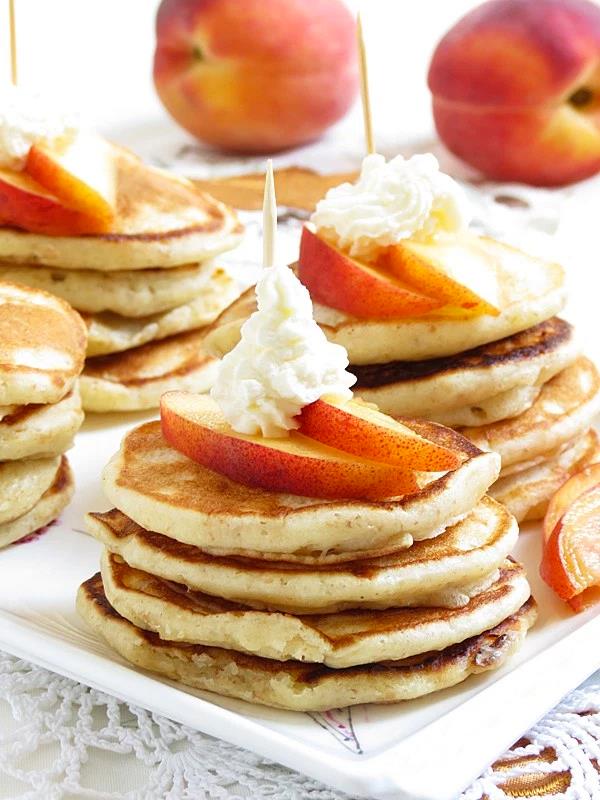 PEACHES AND CREAM MINI PANCAKES {PARTY STYLE}
Peaches and Cream Mini pancakes topped with seasonal peaches, whipped cream and maple syrup. Perfect for a Tea Party or a Brunch!
Lately, I was thinking how to change my blog a little. Iβve decided to focus more on Party Recipes. Therefore, probably in the next couple of months I will post more party recipes. Right now I have a head full of new ideas. While still I will have lots of other recipes as well.
We eat pancakes a lot at my home. Especially my children, they love them. Long time ago I was buying frozen pancakes. But Iβll tell you I hate frozen processed foods. I make everything from scratch. When I make lots of pancakes I freeze them so I can have it for couple of days or even weeks. It depends how often my children want them. I do the same with my waffles. I donβt buy them frozen anymore.
https://i1.wp.com/ilonaspassion.com/wp-content/uploads/2015/08/Peaches-and-Cream-Mini-Pancakes2.jpg