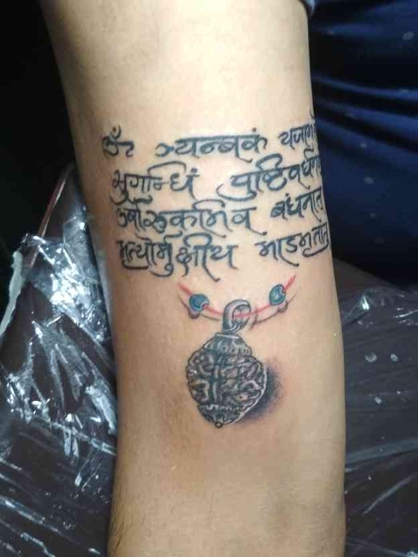 Shiva mantra tattoo with rudraksha on ar